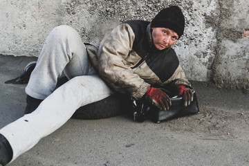 Homeless dirty woman lies on the ground
