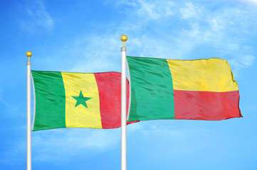Senegal and Benin  two flags on flagpoles and blue cloudy sky