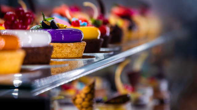 Kolorowe ciastka i desery na ladzie cukierniczej 