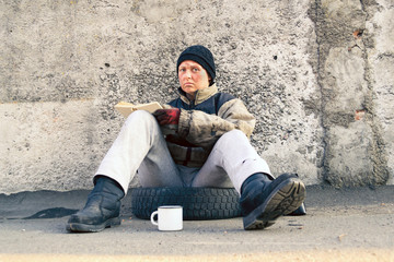 Homeless dirty woman sitting and reading a book