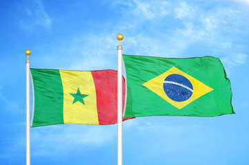 Senegal and Brazil  two flags on flagpoles and blue cloudy sky