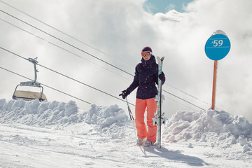 Female skier standing on slope in mountains