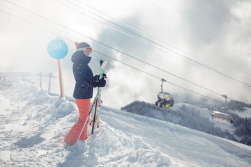Female skier standing on slope in mountains