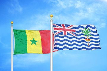 Senegal and British Indian Territory two flags on flagpoles and blue cloudy sky