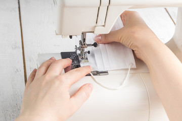 Woman hand using a sewing machine to make mask face fabric, Health care, and coronavirus protect with sew mask homemade.