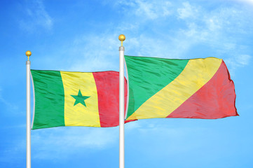 Senegal and Congo  two flags on flagpoles and blue cloudy sky