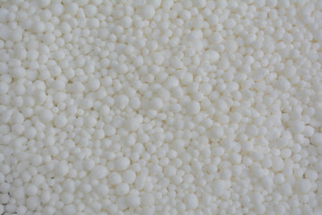 white granules of organic fertilizer look like an unusual porous texture in the community