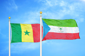 Senegal and Equatorial Guinea two flags on flagpoles and blue cloudy sky