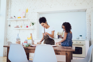 Obraz premium Cheerful mother and daughter preparing pastry together