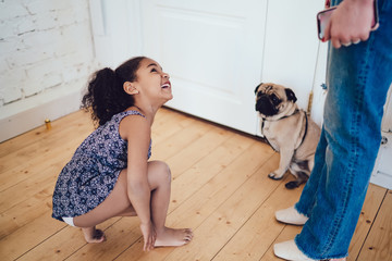 Cheerful girl crouching near pug