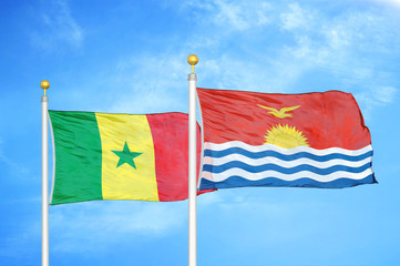 Senegal and Kiribati two flags on flagpoles and blue cloudy sky