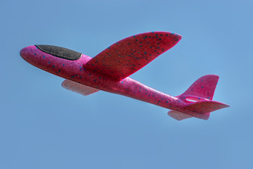 A foam throwing glider plane flies in the blue sky