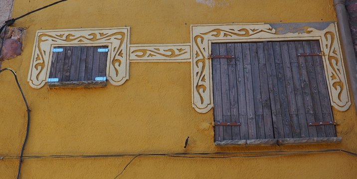 contraventanas de madera color gris con medios arcos  blanco con decoracion begetal, prades, tarragona, espa&ntilde;a, europa 