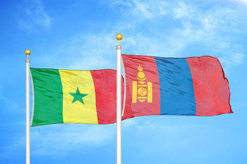 Senegal and Mongolia two flags on flagpoles and blue cloudy sky