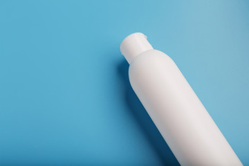 White bottle on a blue background. Free space for text.