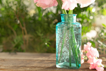 Bouquet of pink sweet peas Lathyrus in beautiful transparent vase on wooden background. Home garden,rustic. Spring concept. International Women's Day, March 8 and Valentine's Day,14 of February