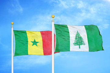 Senegal and Norfolk Island two flags on flagpoles and blue cloudy sky