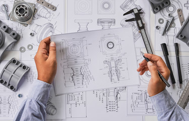 Engineer technician designing drawings mechanical parts engineering Engine.manufacturing factory...