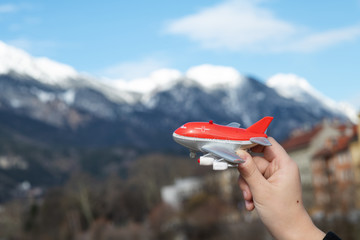Child's hand holds toy airplane on Insbluk Austria