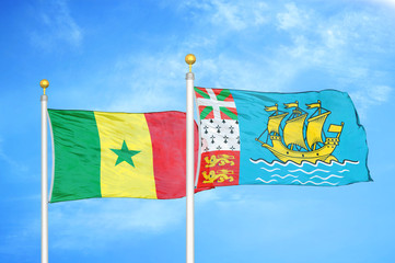 Senegal and Saint Pierre and Miquelon two flags on flagpoles and blue cloudy sky