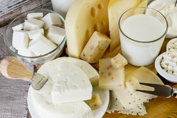 Different types of cheese on a wooden table. Background of cheese.