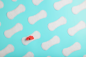 Many Sanitary pads on a blue background in the form of a diagonal pattern with a flower. Textured background all over the screen.