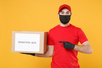 Delivery man employee in red cap blank t-shirt uniform face mask glove hold donations cardboard box isolated on yellow background studio Service quarantine pandemic coronavirus virus 2019-ncov concept