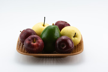 Fruits on a plastic basket on a white background.