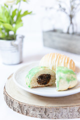 gefüllte bunte und farbige Eier aus Hefe mit Zuckerguss zu Ostern auf Teller auf weißer Decke
