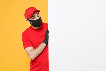 Delivery man in red cap t-shirt uniform sterile face mask gloves hold blank sign board isolated on...