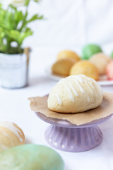 gefüllte bunte und farbige Eier aus Hefe mit Zuckerguss zu Ostern auf Teller auf weißer Decke