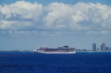  Huge modern MSC Cruises cruiseship or cruise ship liner MSC Divina at sea with skyline of Miami or...