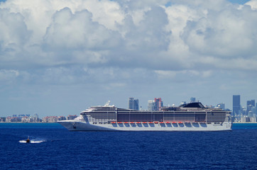 Huge modern MSC Cruises cruiseship or cruise ship liner MSC Divina at sea with skyline of Miami or...