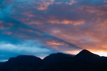 A beautiful sunrise over the mountains as the first rays of sunshine light up the clouds with beautiful colours.  - 335837268
