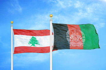 Lebanon and Afghanistan  two flags on flagpoles and blue cloudy sky