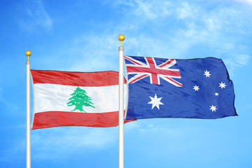 Lebanon and Australia  two flags on flagpoles and blue cloudy sky
