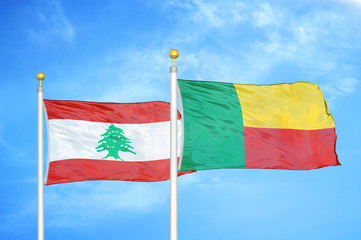 Lebanon and Benin  two flags on flagpoles and blue cloudy sky