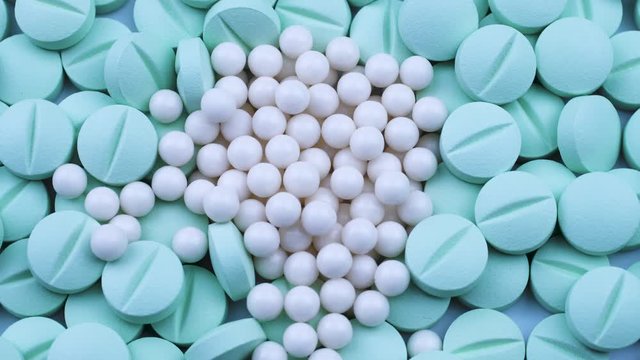 White granules are scattered on round bright green antibiotics. Rotation