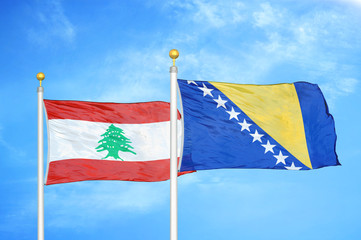 Lebanon and Bosnia and Herzegovina  two flags on flagpoles and blue cloudy sky