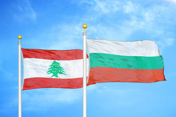 Lebanon and Bulgaria  two flags on flagpoles and blue cloudy sky