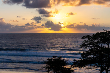 Fototapeta na wymiar Shocking sunrise among the clouds on the beach.