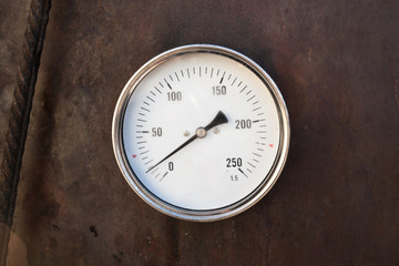 Axial thermometer mounted in rusty steel stove