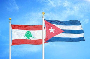Lebanon and Cuba two flags on flagpoles and blue cloudy sky