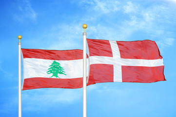 Lebanon and Denmark two flags on flagpoles and blue cloudy sky