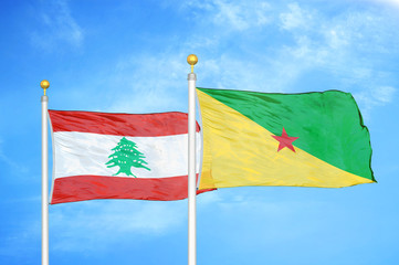 Lebanon and French Guiana two flags on flagpoles and blue cloudy sky