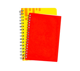 Two paper note diary of red and yellow color placed on top of each other