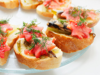 Snack sandwich with sprats cucumber and tomatoes and dill. Delicious sandwiches on a plate.