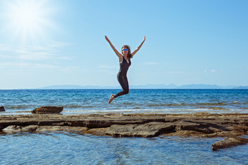 Fototapeta na wymiar Woman jumps high on the beach
