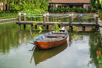 Obraz premium Small wooden boat on the Lang Co Bay, where you can see the bridge on Ah1 Road across the Lang Co Bay to the Hai Van Tunnel, connect Hue and Danang Vietnam.