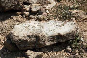Large gravel from the mountains that are outdoors on the ground.